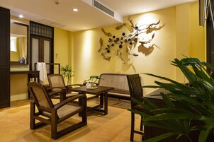 Un salón moderno con un sofá, sillones, una mesa de centro y un adorno en la pared.