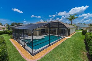 Une maison moderne dotée d’une piscine couverte et d’une pelouse bien entretenue.