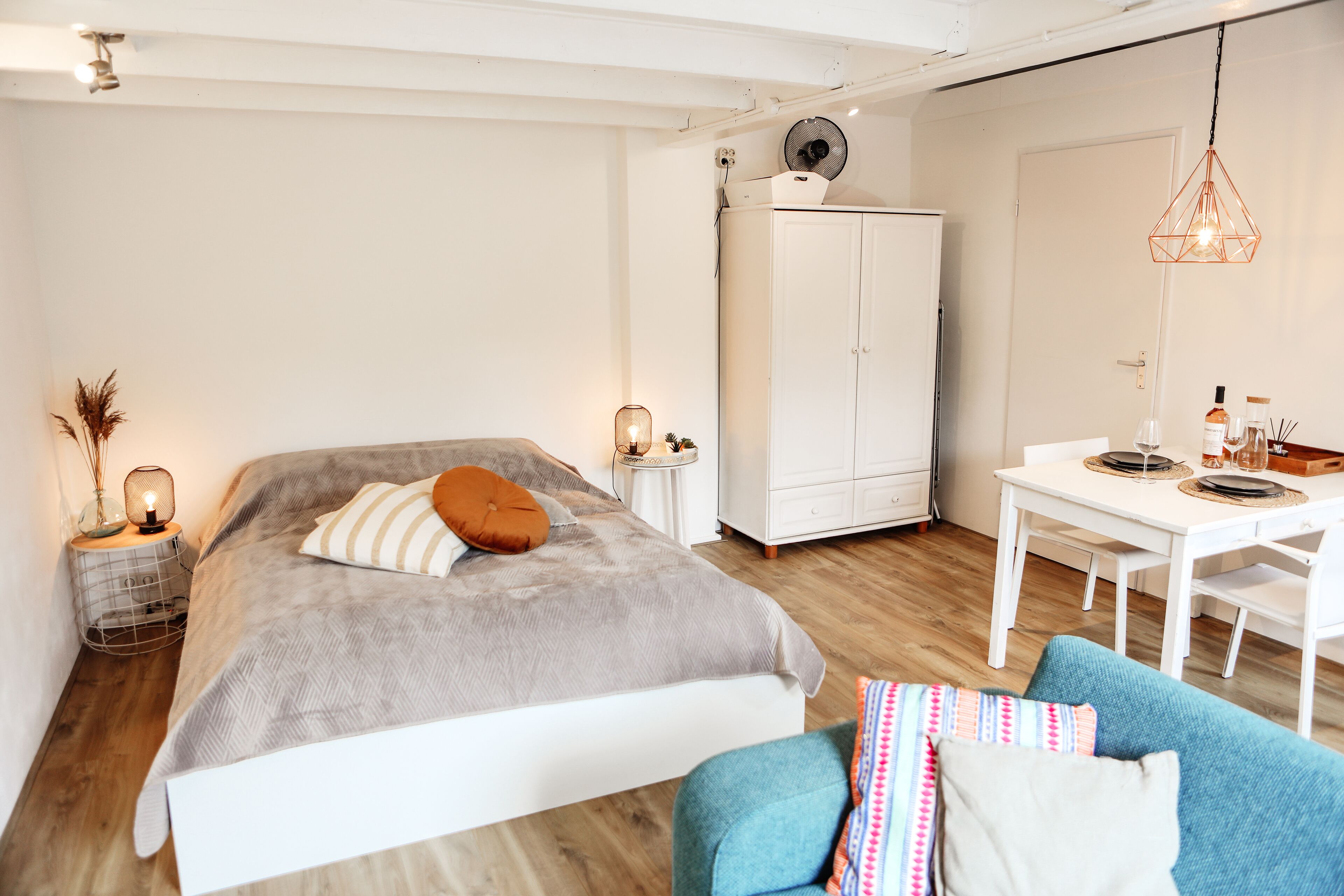 Een slaapkamer met een bed, een kledingkast, een bureau en een stoel.