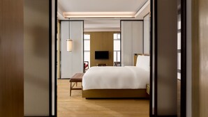 A modern hotel room with a large bed, a TV, and a wooden floor. - The PuXuan Hotel and Spa (Beijing)