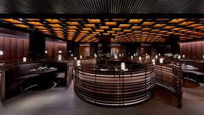 A modern interior with a central round bar, seating areas, and a patterned ceiling. - The PuXuan Hotel and Spa (Beijing)