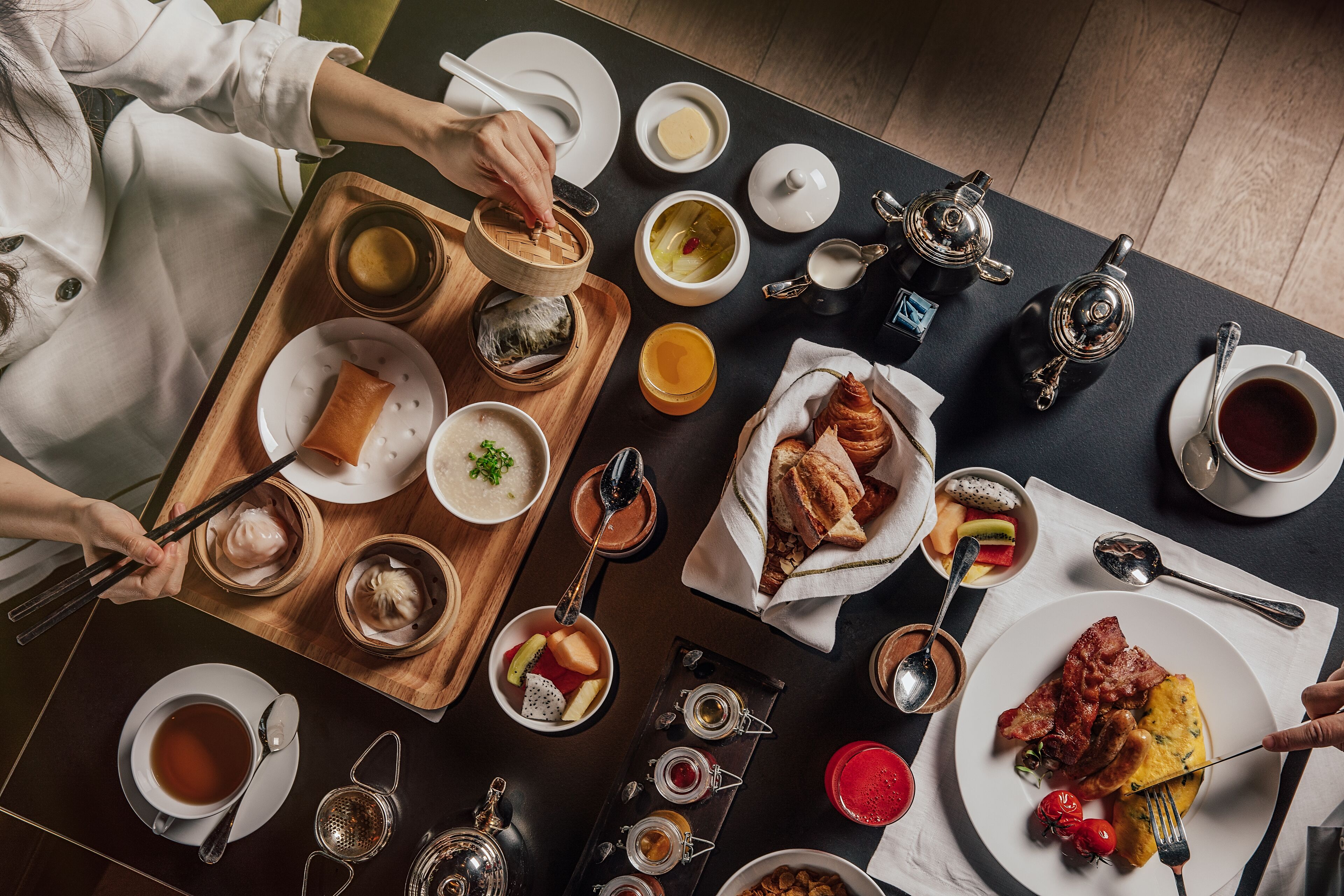 A dining table with various dishes, including dumplings, soup, and a plate of bacon and eggs.