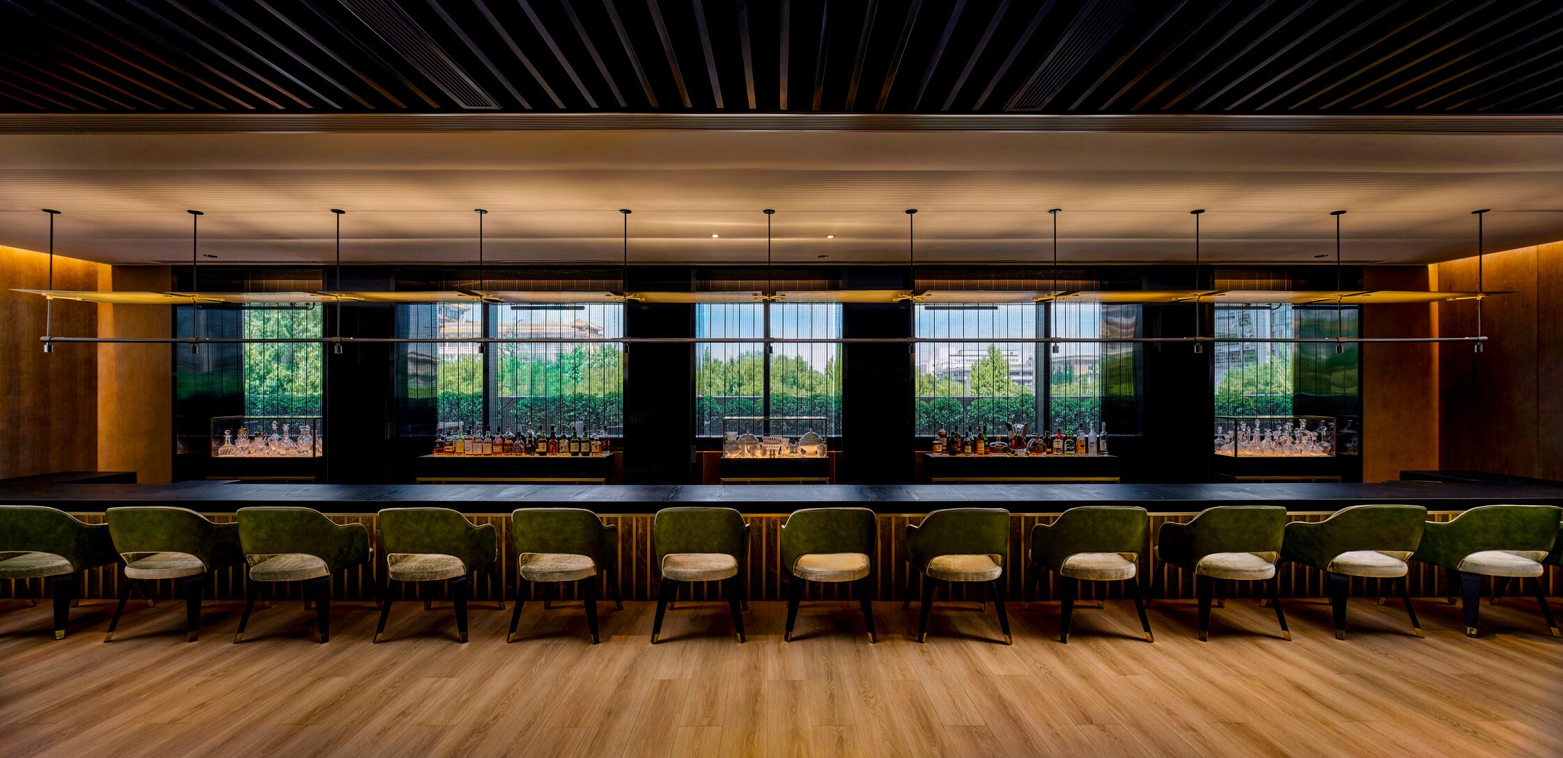 Área de bar com diversos arranjos de assentos e vista para o verde lá fora.