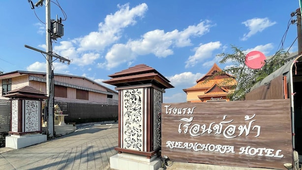 The exterior of the Tanjong Bungakota Hotel with a traditional Thai architectural style, a wooden signboard with the hotel's name, and a clear blue sky in the background.