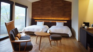 A modern hotel room with two beds, a wooden ceiling, a dining area with a table and chairs, and a view of the outdoors. - Yufuin Rikka (Yufu)
