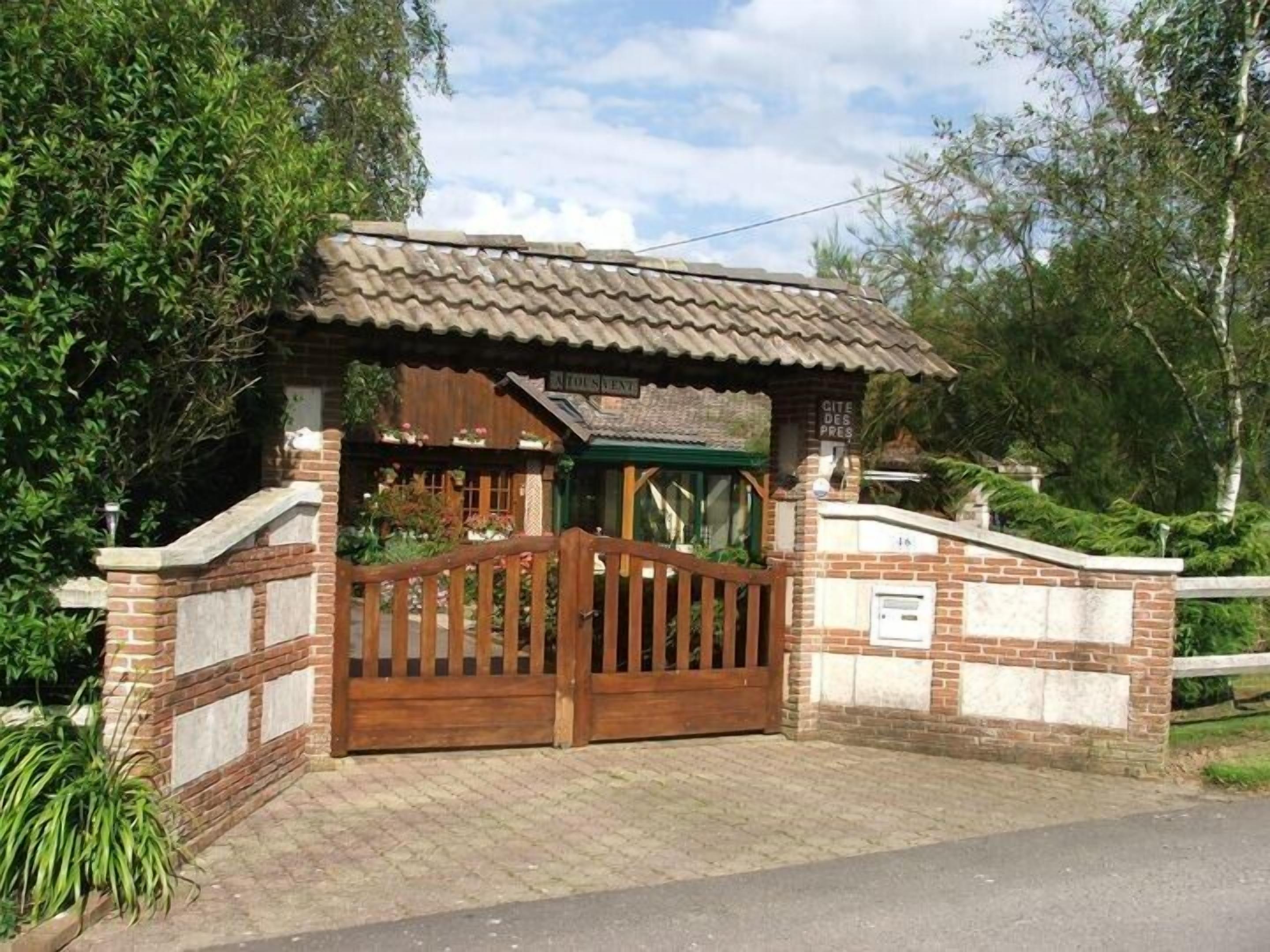 A brick building with a tiled roof and a wooden gate.