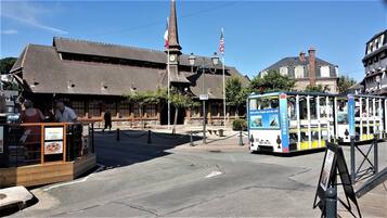 A historic building with a clock tower, a tram, and a sign for 'Nos Pizzas.'