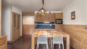 A modern kitchen with wooden cabinets, a central island, and a pendant light.