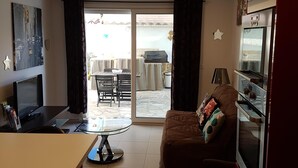 A modern kitchen with a refrigerator, oven, and dining area with a table and chairs.