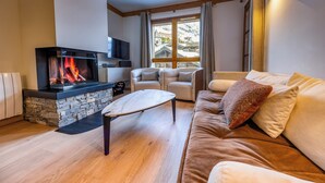 Ein gemütliches Wohnzimmer mit Kamin, einer Couch und einem Couchtisch.