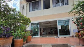 A guesthouse entrance with a welcoming sign, steps leading up to the entrance, and potted plants around. - Bella Bella River View (Bangkok)