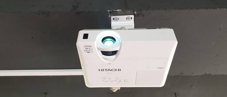A HITACHI projector mounted on a wall.
