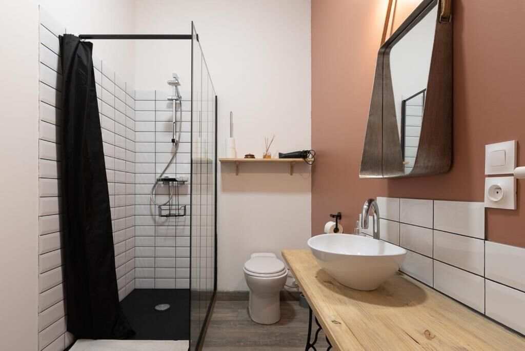 A modern bathroom with a shower, toilet, and sink.