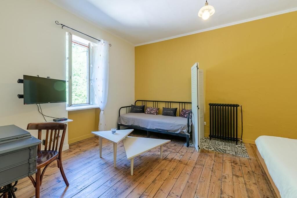 A room with a bed, a desk, a chair, a TV, and a window.