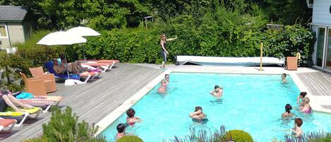 Una piscina al aire libre de temporada, sombrillas