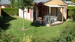 Ein kleines, eingeschossiges Gebäude mit überdachter Terrasse.