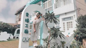 Una persona de pie frente a un edificio con un letrero que dice "Happy Engineering".