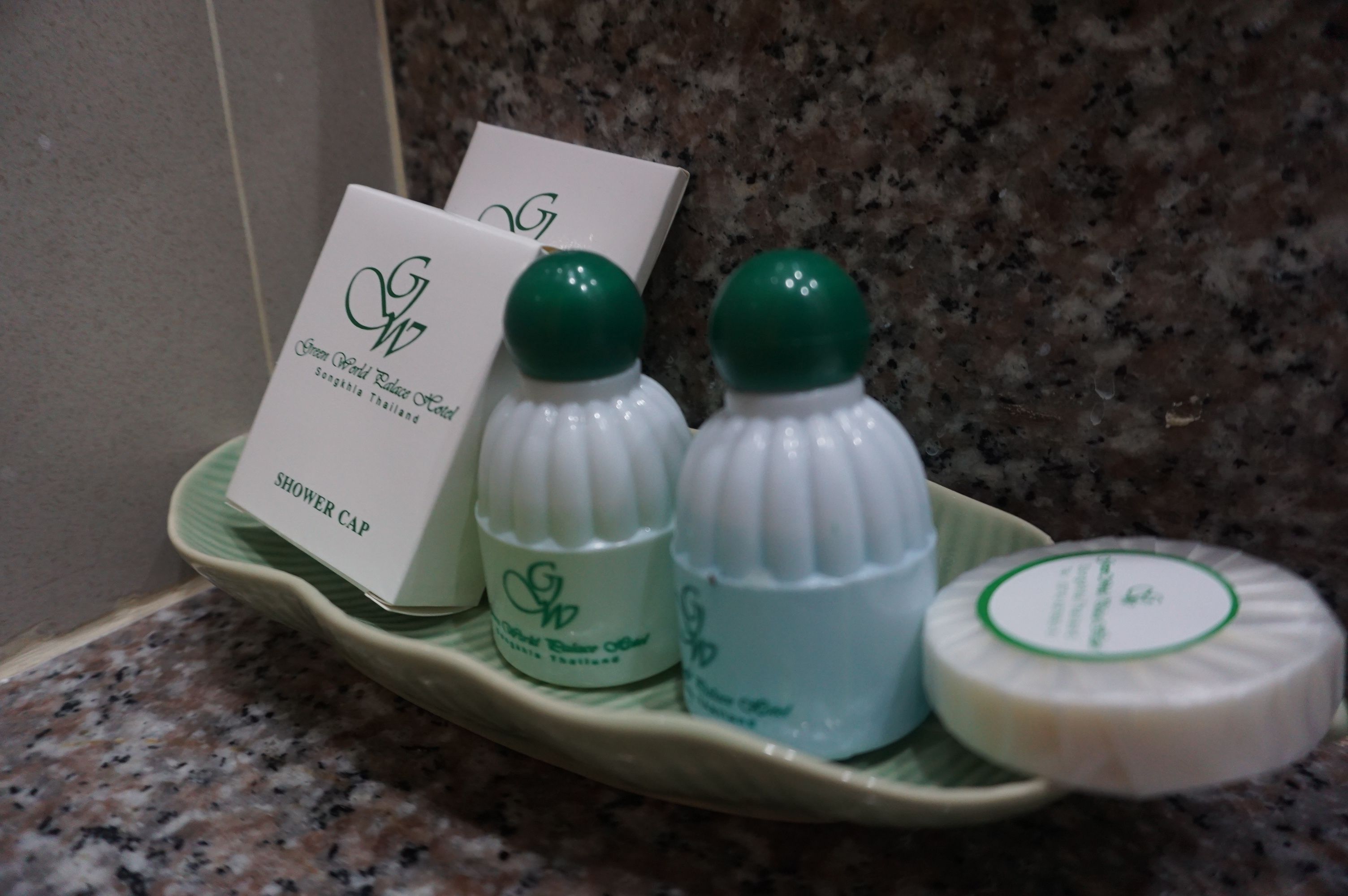 A tray with a shower cap, two bottles of lotion, and a bar of soap.