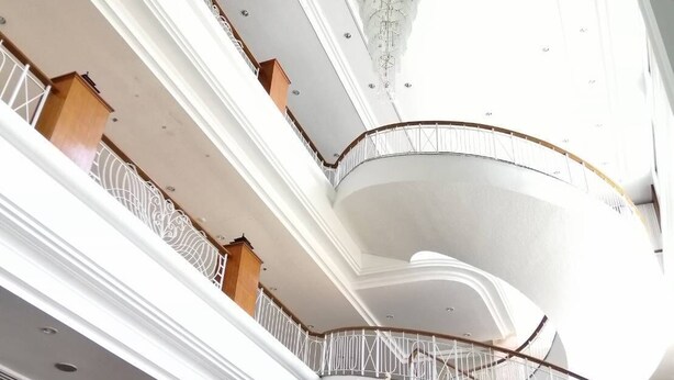 A multi-level interior with a central round table, a chandelier, and a reception area. - Green World Palace Hotel (Songkhla)