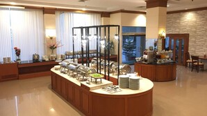 A hotel lobby with a buffet area, a reception desk, and a stone wall. - Green World Palace Hotel (Songkhla)