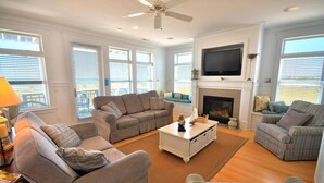 A living room with a fireplace, a television, and multiple seating areas.