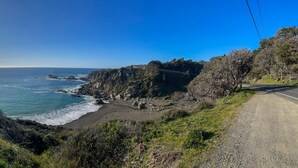 A coastal road with a beach and rocky cliffs.