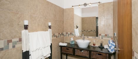 Ein Badezimmer mit Waschbecken, Spiegel und Handtuchhalter.