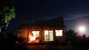 Una casa pequeña de dos pisos con un porche y una escalera visible.
