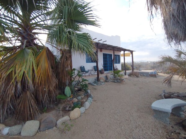 A house with a patio, outdoor seating, and a garden with rocks and plants.