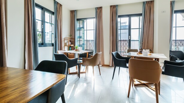 A modern dining area with a wooden table, black and brown chairs, and large windows with curtains. - Kiwi Villa (Magong)