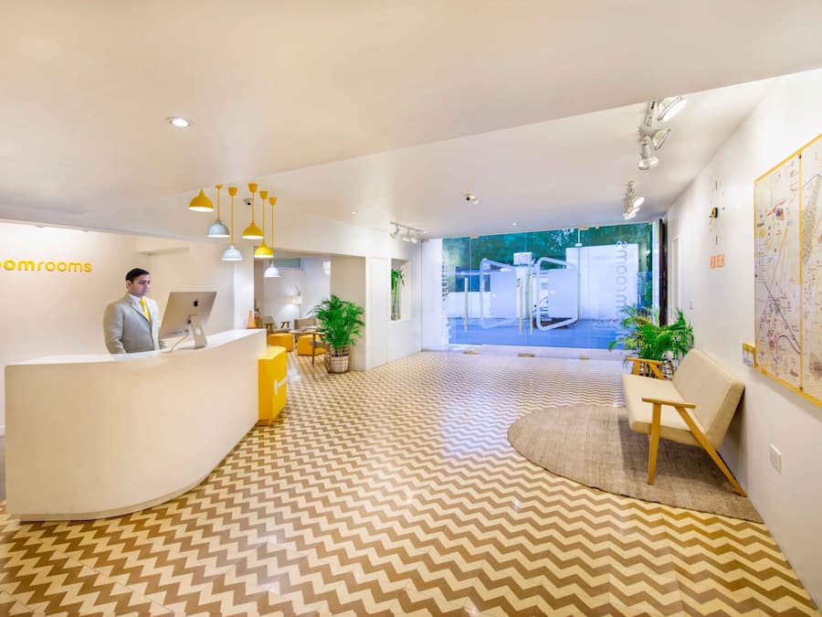 A modern reception area with a chevron-patterned floor, a reception desk, and a large window with a view of the outdoors.