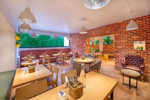 Un restaurante acogedor con paredes de ladrillo, mesas de madera y asientos cómodos.