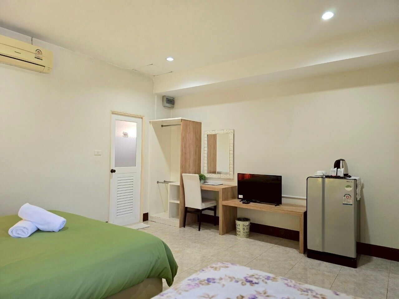 Une chambre d’hôtel équipée d’un lit, d’un bureau, d’une télévision, d’un réfrigérateur et d’une salle de bain.