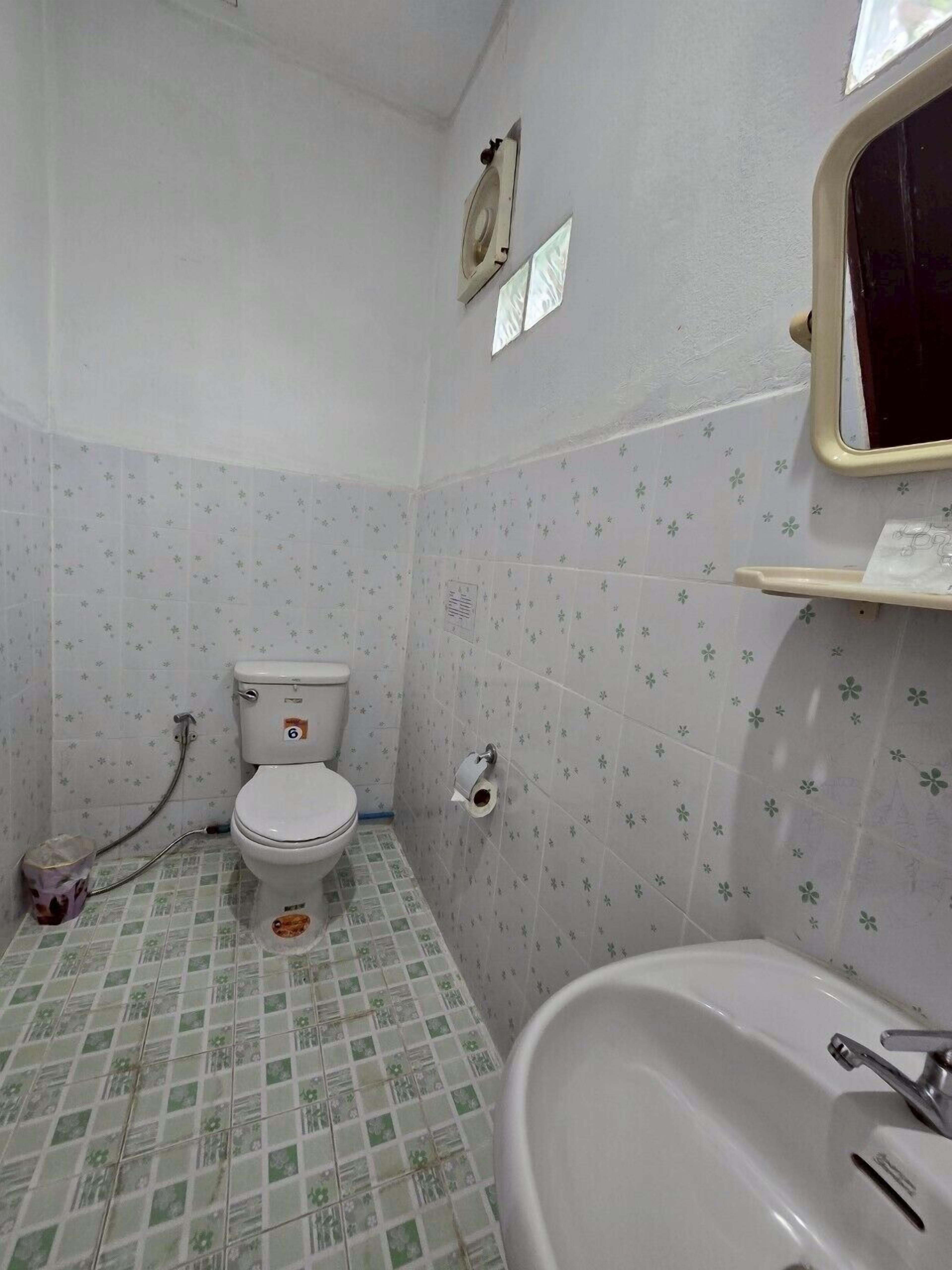 Un baño pequeño con inodoro, lavabo y espejo.