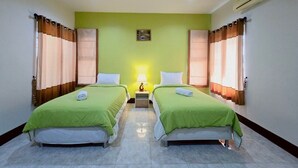 A room with two beds, a nightstand with a lamp, and an air conditioning unit on the wall. - Suansiri Resort (Mae Chan)