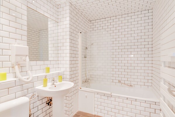 Departamento urbano | Baño | Tina con regadera, secadora de cabello, toallas 