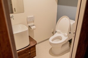 A bathroom with a toilet, sink, and mirror. - Kyoto Pedal (Kyoto)