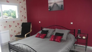 A bedroom with a bed, a chair, a nightstand, and a window. - Chambres d'Hôtes Le Saint Ô Détente (Saint-Orens-de-Gameville)
