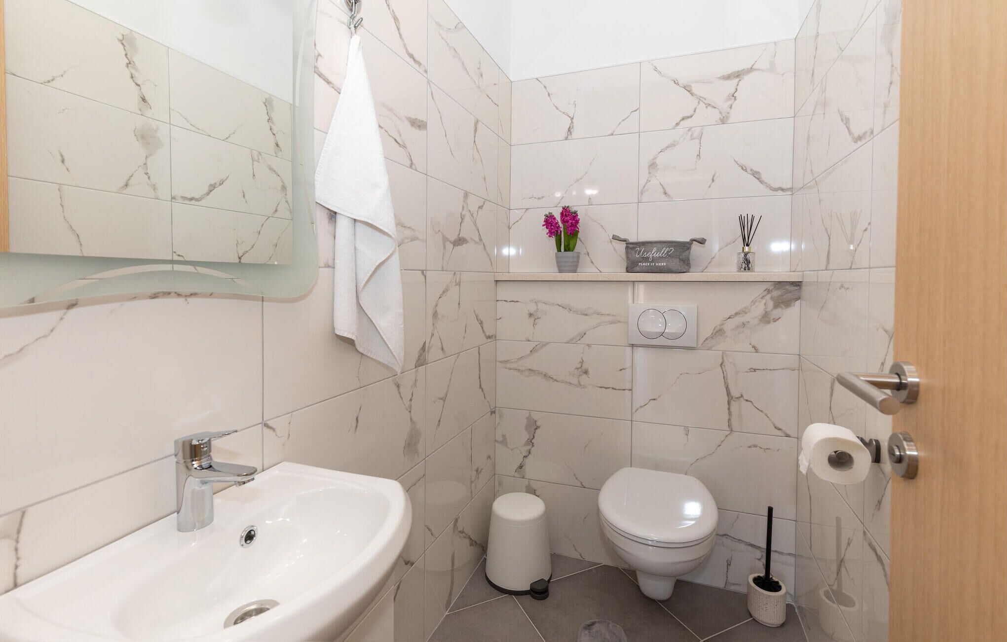 Un baño con lavamanos, inodoro y espejo.