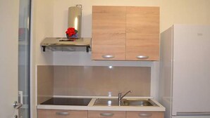 Una cucina con lavello, mobili in legno e frigorifero bianco.