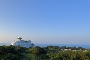 Un gran crucero amarrado en un puerto, con vistas claras a la vegetación y edificios circundantes.