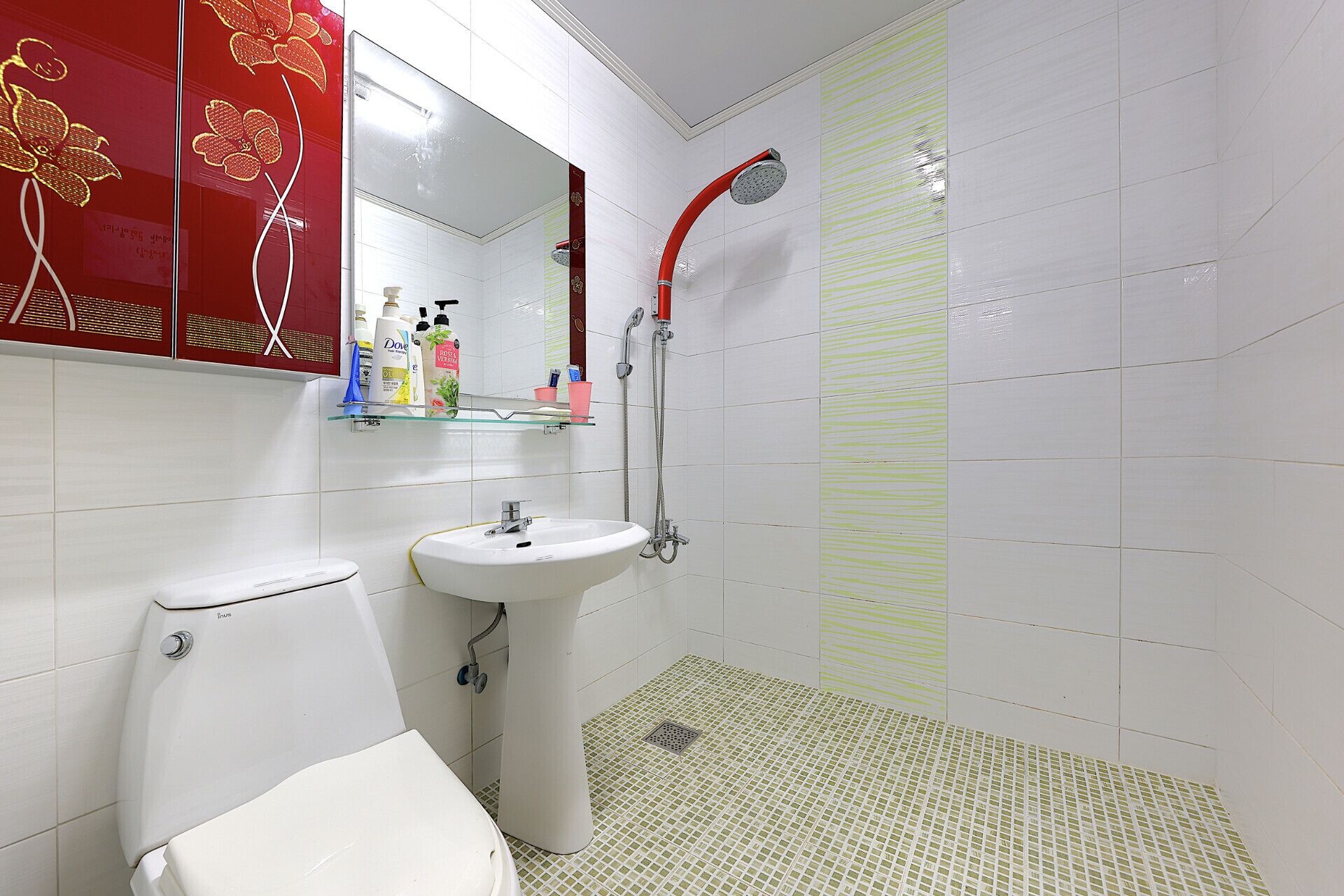 Un baño con inodoro, lavamanos y ducha.