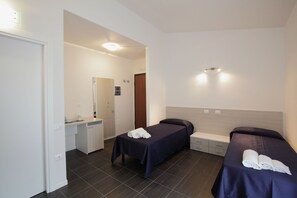 A hotel room with two beds, a desk, and a bathroom. - Residence Città Ideale (Urbino)