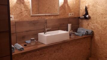 Une salle de bain avec un meuble-lavabo en bois, un grand miroir et un porte-serviettes.