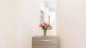 A bathroom vanity with a mirror, a vase of flowers, and three drawers. - Amazing view in Cusco (Cusco)
