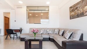 A modern living room with a sectional sofa, a glass coffee table, and a desk with a chair. - Amazing view in Cusco (Cusco)