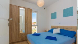 A bedroom with a bed, a wardrobe, and a window with a view. - 1 bedroom cozy apartment in Vir (Vir)