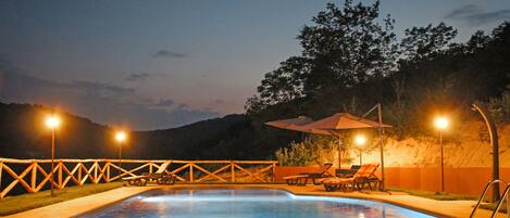 Una piscina al aire libre de temporada, sombrillas