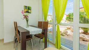 Un coin repas avec une table, des chaises et un vase de fleurs.