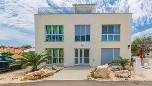 Un bâtiment moderne à deux étages, doté d’un toit plat, de grandes fenêtres et d’un balcon.